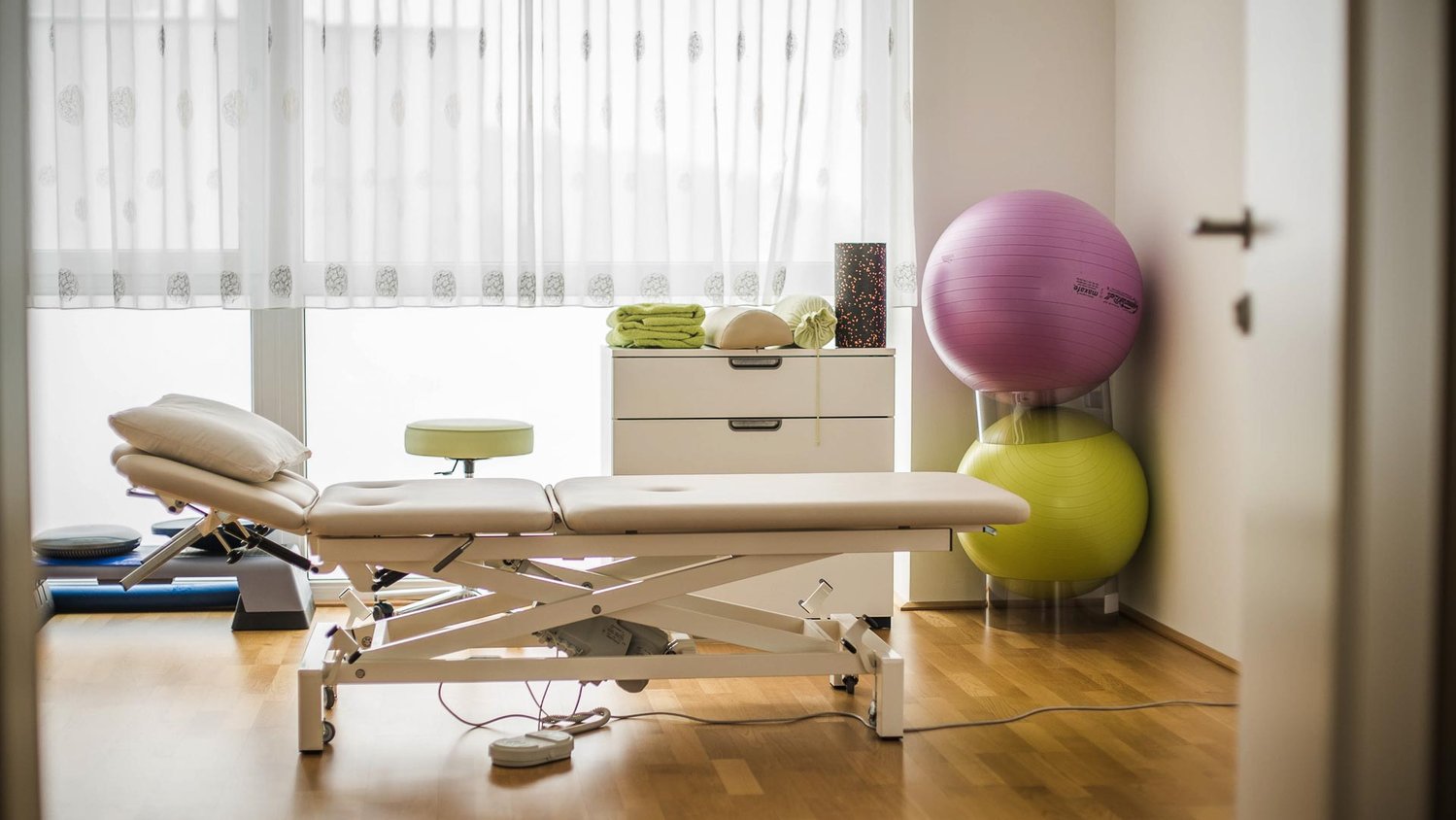 Praxis für Physiotherapie mit einer Behandlungsliege und Gymnastikbällen